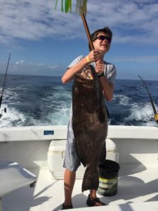 Aaron Hanania lifts the 80 pound Grouper he caught while deep sea fishing outside of Cozumel, Mexico