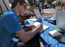 Aaron autographs copies of his new book The King's Pawn at the 2019 Printers Row Literature Fest. Photo courtesy Ray Hanania